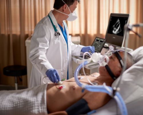 Compact 5000 Series shown in critical care setting with a physician performing a cardiac scan.  