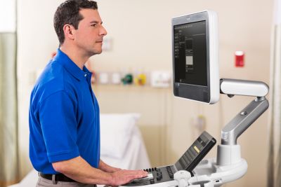 Clinician operating Philips mobile ultrasound system at the patient bedside