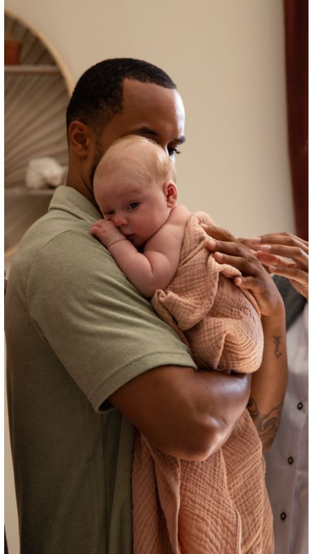 Family holding their baby with midwife next to them