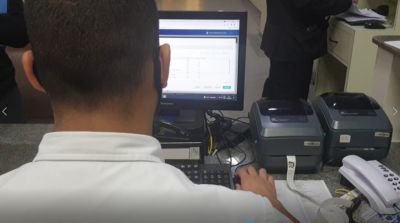 Profissional de saúde inserindo dados no sistema Tasy em um computador de mesa