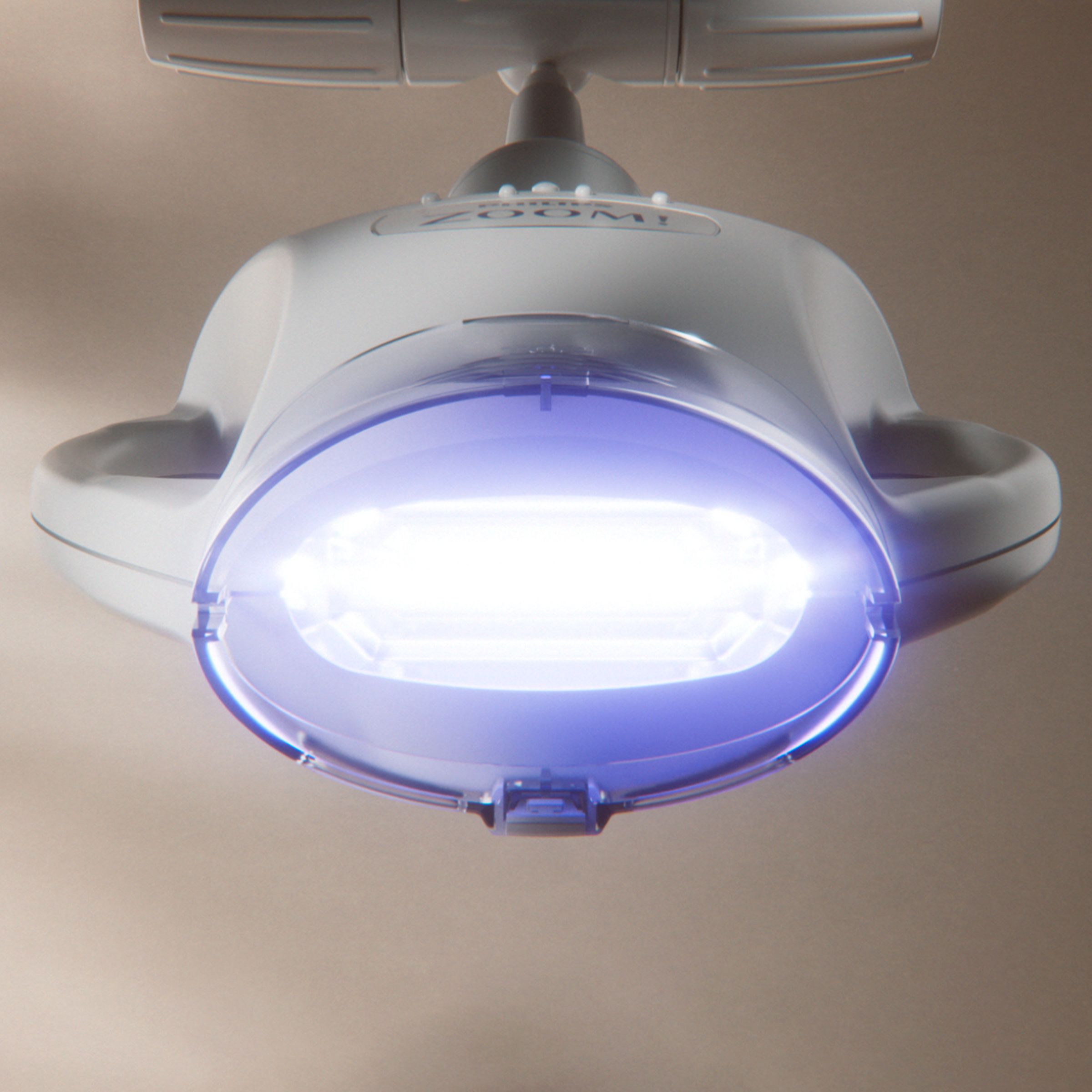 Dental professional holding a shade guide in front of a patient&rsquo;s smile