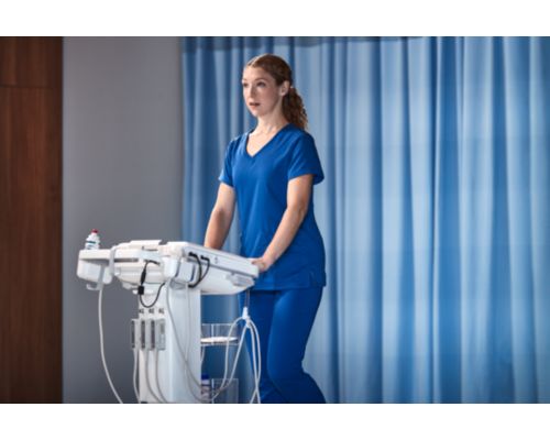 Photo of a female clinician remotely connecting with a specialist via teleultrasound from an ultrasound system while performing an ultrasound exam.  