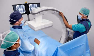 Clínicos operando el sistema de arco en C móvil Philips Zenition 90 durante un procedimiento de imagenología quirúrgica.