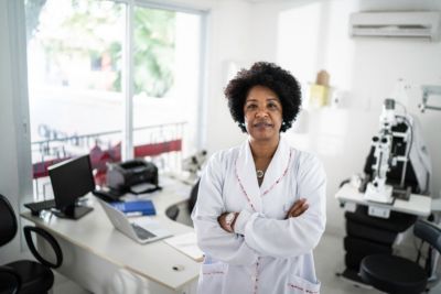 Profissional de saúde de jaleco branco está em uma sala de exames