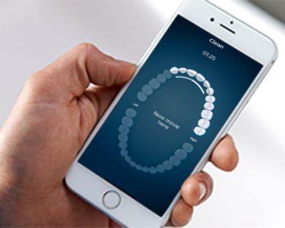 Hand houdt een smartphone met de Philips Sonicare-app vast
