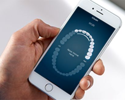 Hand holding a smartphone with the Philips Sonicare app