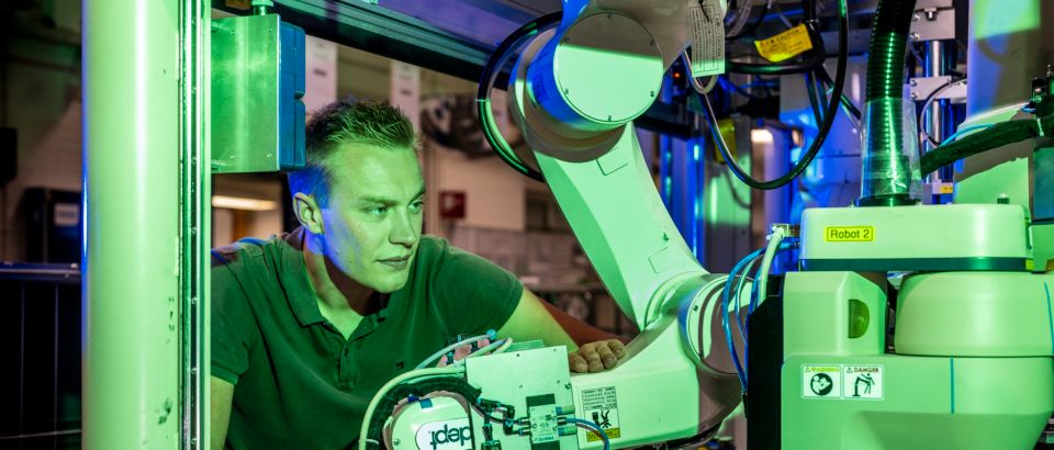 Technician works alongside robotic arm