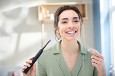 Mobil uygulamalı Philips ExpertClean 7500 sonik elektrikli diş fırçasını kullanan kadın