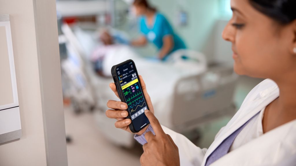 Physician checking mobile outside patient room