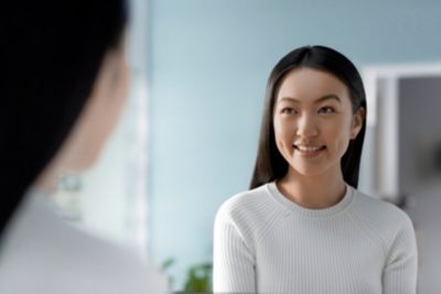 バスルームの鏡に映る自分の姿に微笑む女性