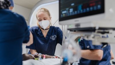 Medical team caring for a patient in a clinical setting with vital signs monitor