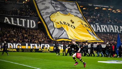 En ung pojke bär en Philips hjärtstartare (AED) ut på fotbollsplanen