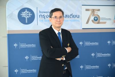 ชูศักดิ์ เบนจามิน วงศ์สุรีย์ ยืนอยู่ด้านหน้าป้ายจัดแสดงครบรอบ 75 ปี โรงพยาบาลกรุงเทพคริสเตียน