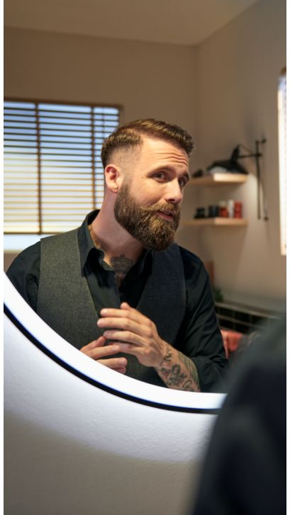 Mann rasiert seine Achselhöhlen mit einem Multigroom