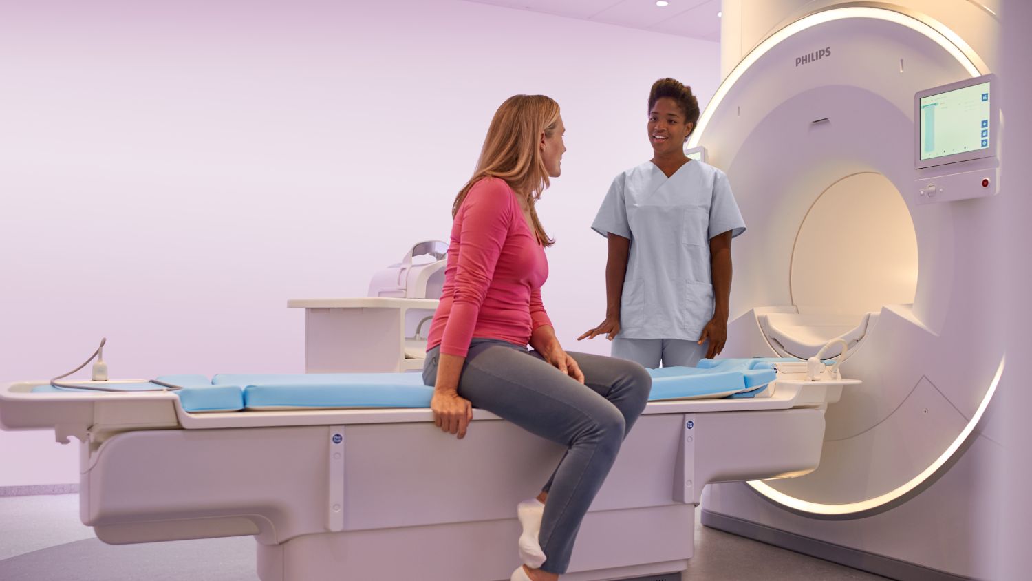 Patient sitting on table talking to operator