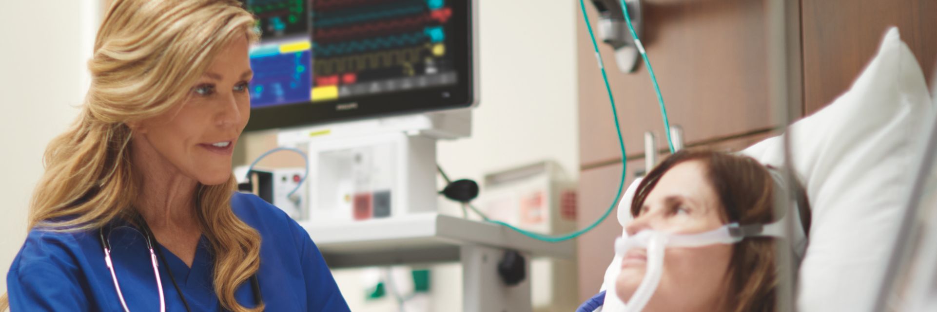 Nurse speaking with patient in hospital bed