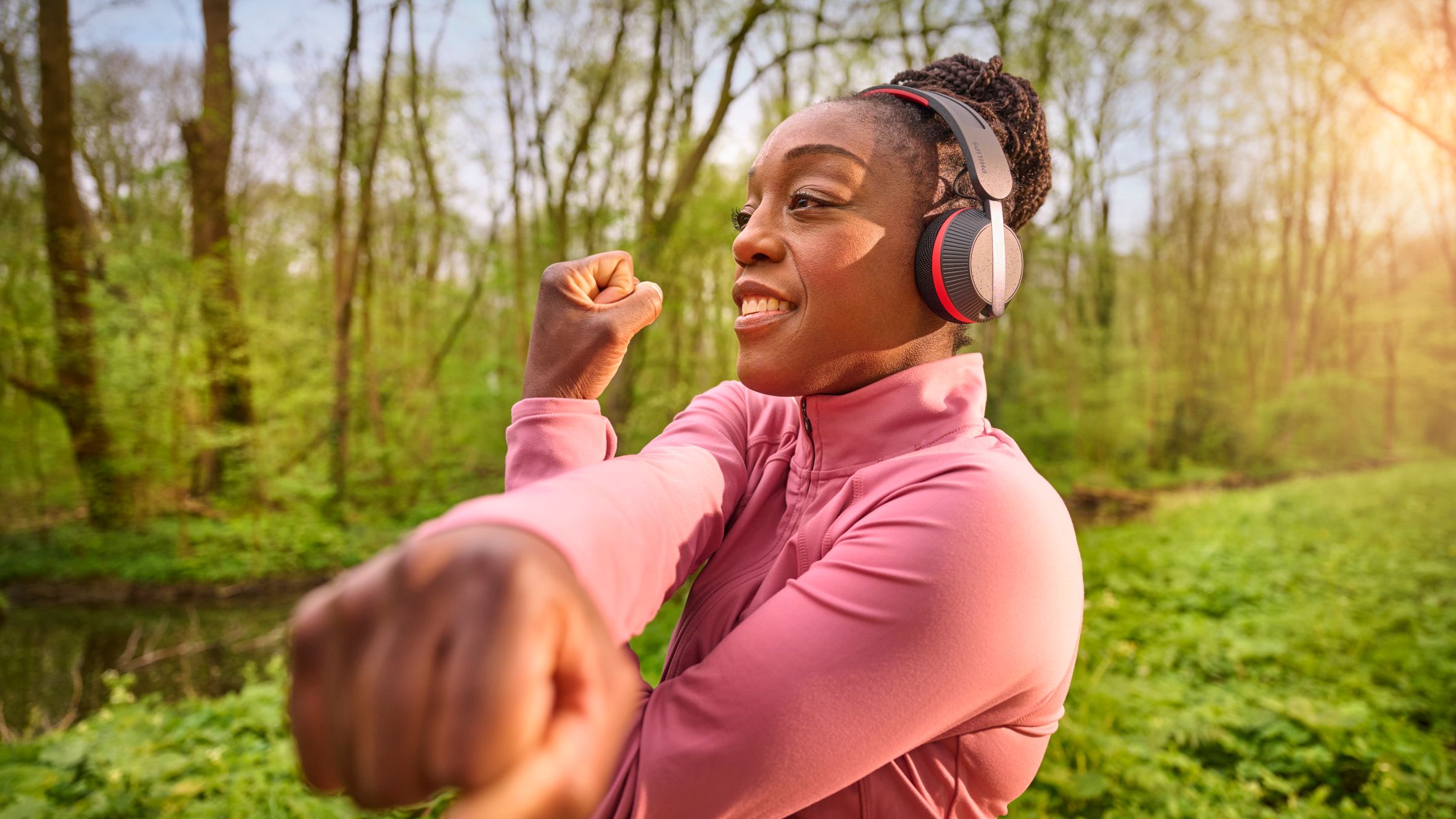 Woman wearing Philips sports headphones during outdoor training, designed for comfort and stability while moving.