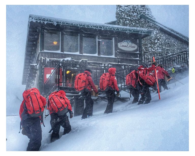 image of team hiking up snowy mountain