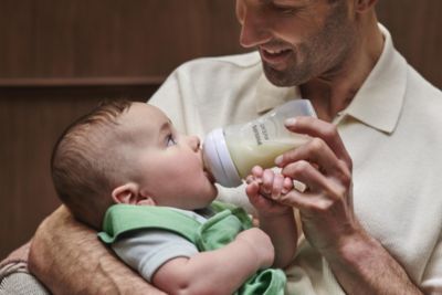Baba bebeğini Philips Avent biberonuyla besliyor