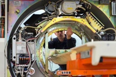 A person working on the interior of a large industrial machine