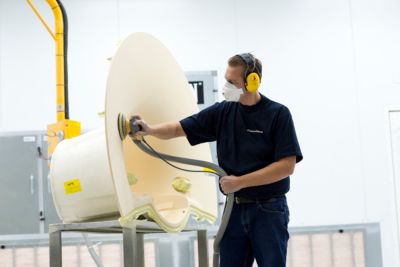 Technician refinishing medical equipment housing during Philips refurbishment process
