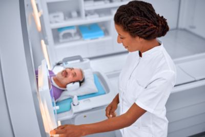 Patient in MRI machine while technician operates MRI