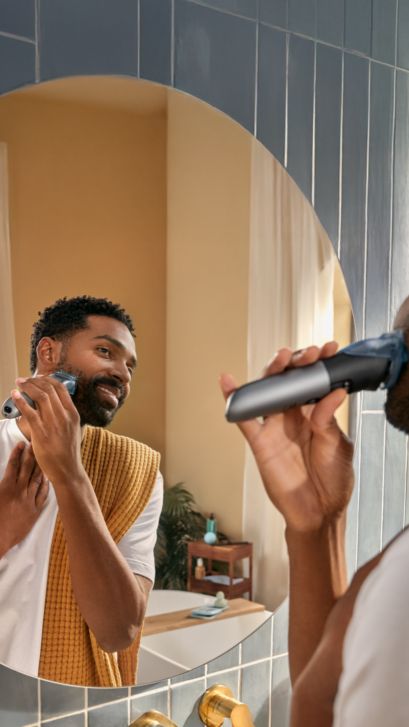 Man shaving his beard in the mirror