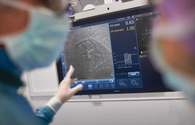 Clinicians reviewing coronary imaging and iFR measurements on screen