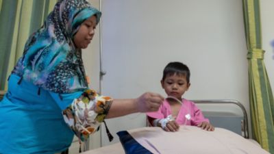 Child with IV and mother in hospital room