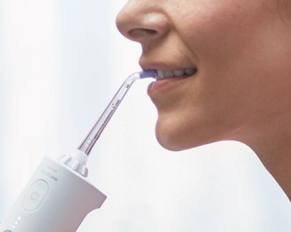 Patient uses the power flosser on front teeth