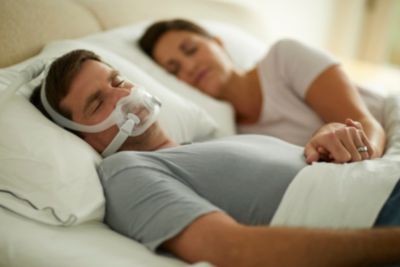 DreamWear Full Face in-use, close-up, male adult sleeping on back, female spouse in background