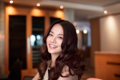 使用 StyleCare Prestige 自動捲髮器的女性捲髮