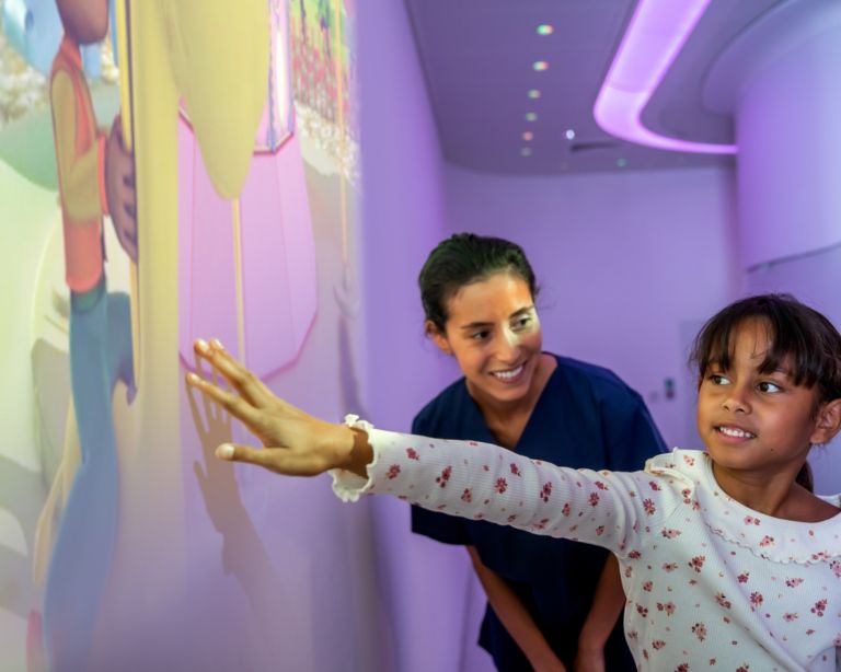 Pediatric Coaching, Child playing with Ambient Experience Ollie in Space theme prior to an MRI exam.