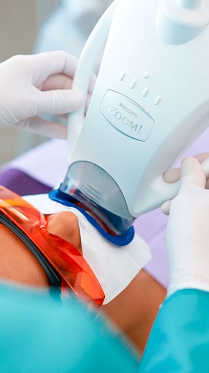 Un professionnel de la santé bucco-dentaire qui ajuste une lampe Philips Zoom!