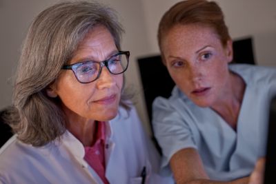 Clinicians reviewing MRCAT brain imaging data on screen in clinical setting