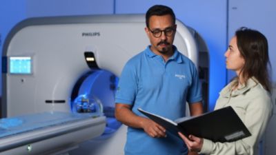 Profissionais de saúde revisando informações ao lado do tomógrafo Philips