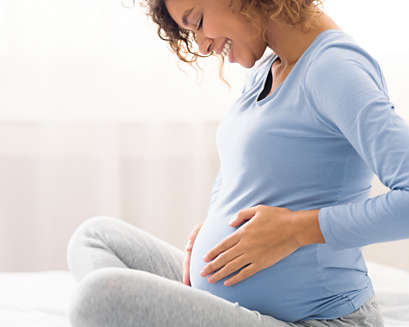 A pregnant woman feeling her baby kick.