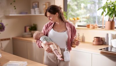 De holdingsbaby van de moeder in keuken