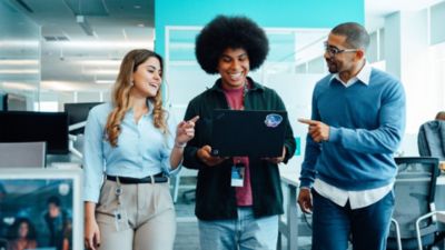 Philips employees collaborating and reviewing laptop in office environment