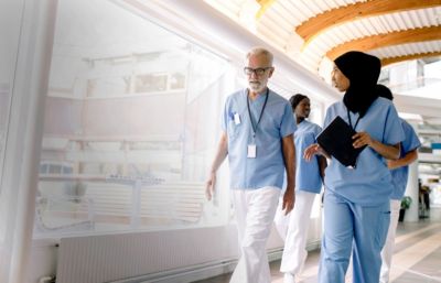 Clinicians walk through a hospital corridor