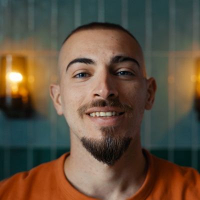 Un hombre con barba Van Dyke mira a la c&aacute;mara en una habitaci&oacute;n muy iluminada