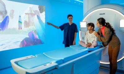 Una enfermera tranquiliza a un niño y a su madre antes de una resonancia magnética con Philips Pediatric Coaching