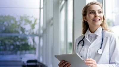 Jeune médecin femme souriante et portant un stéthoscope​.