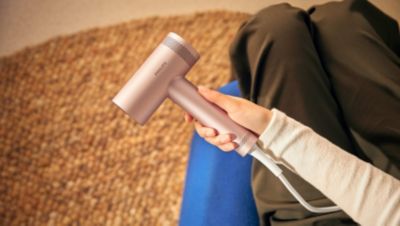 Person, die zu Hause einen Föhn hält
