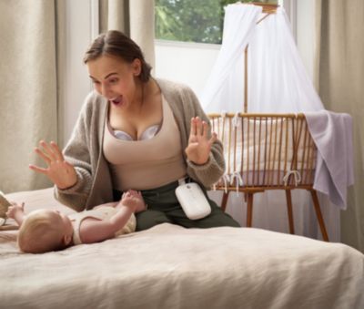 Die Mutter benutzt eine Freipumpe während der Betreuung des Babys