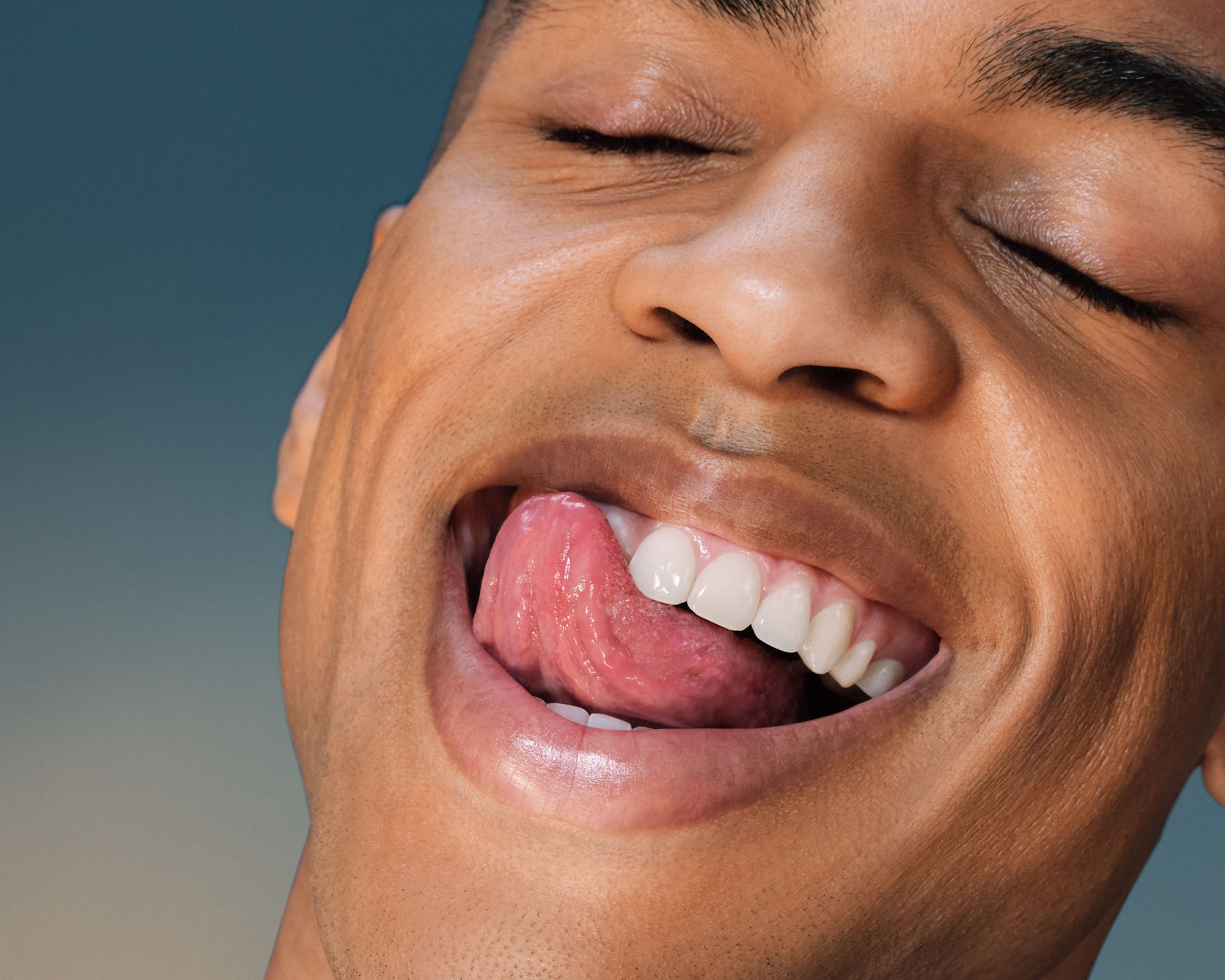 A patient licking his teeth after whitening.