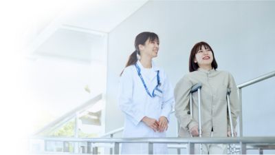 医療従事者が松葉杖を使う患者を支えている
