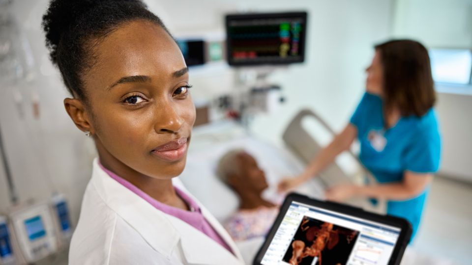 A healthcare provider examines a computer screen displaying Philips remote telehealth software