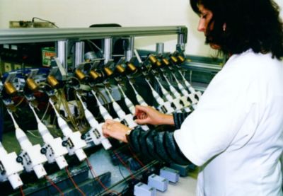 Philips employee testing handheld devices on production line
