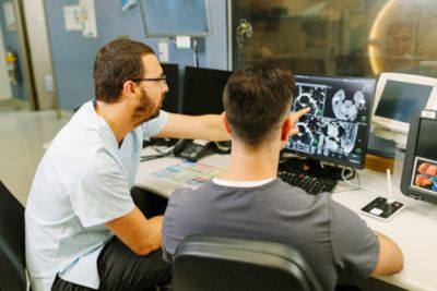 un manipulateur et un radiologue observent l’écran de la console IRM.